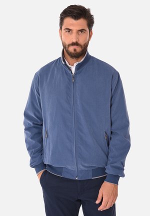 Giacca bomber blu con una texture liscia, chiusura a zip e polsini a coste. Caratterizzata da tasche laterali e un design del colletto classico.
