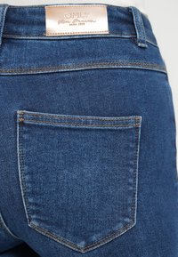 Μπλε τζιν με δομημένη εφαρμογή, που διαθέτει δερμάτινη ετικέτα με το λογότυπο "ONLY" και αντίθετη ραφή στην πίσω τσέπη.