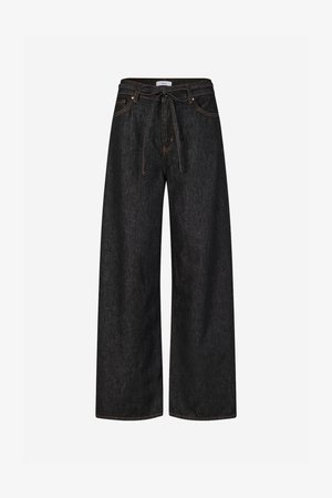 Tmavomodré široké nohavice z džínsoviny s vysokým pásom, opaskom na zaväzovanie a kontrastným oranžovým prešívaním. Majú klasický dizajn s piatimi vreckami.