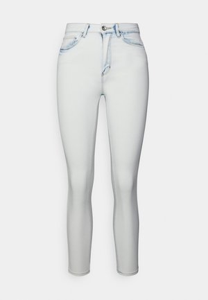 Jeans justos em denim azul claro, com cintura alta, desgaste sutil e um fecho de zip clássico com um único botão.