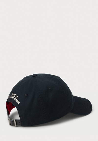 Melnās kokvilnas cepure ar regulējamu siksniņu, uz kuras aizmugures balta izšūta uzraksts "POLO Ralph Lauren" un sarkana oderējuma iekšpusē.