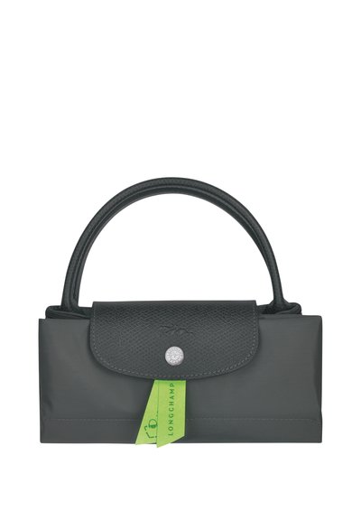 Black foldable handbag with textured leather flap, circular silver snap closure, short handles, and a green Longchamp tag.