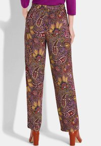 Pantalons évasés avec un motif paisley multicolore présentant des nuances de violet, d'orange et de vert, dotés d'une taille élastique et de poches latérales.