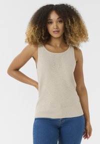 Beige gebreide mouwloze top met geribbelde zoom en verticale details aan de voorkant. De stof heeft een gladde textuur. De stijl is aansluitend.