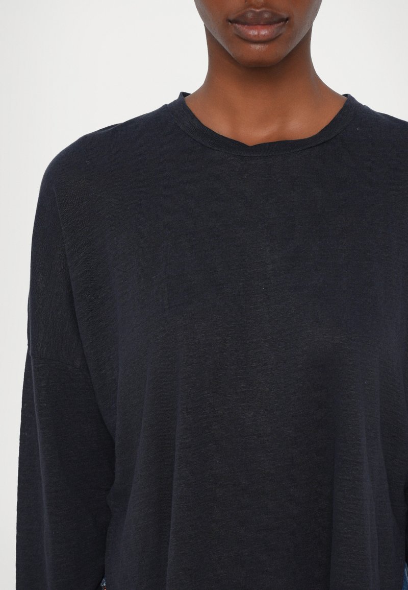 Schwarzes Langarm-T-Shirt mit Rundhalsausschnitt, aus weichem Stoff gefertigt. Bietet eine lockere Passform und sichtbare Nähte.