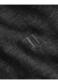 Šedá pletená látka s měkkou texturou obsahuje malý kontrastní vyšívaný číslici tři v dolním rohu.