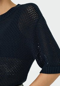 Maglione blu navy lavorato a maglia con trama aperta, maniche corte e collo a costine. Tessuto testurizzato con una vestibilità ampia, adatto per essere indossato a strati.
