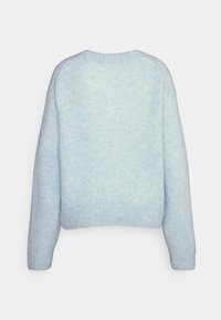Pull doux de couleur bleu clair, avec un col rond, une coupe décontractée et des poignets et un ourlet côtelés, présentant un motif de couleur subtil et mélangé.