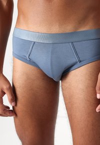 Grå bomullsunderkläder med en mjuk elastisk midjeband, som har en snug passform och slät textur. Sidsömmar och framficka för stöd.