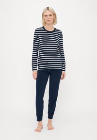 Gestreepte lange mouw top in marineblauw en wit, gecombineerd met marineblauwe tapered joggers, met een relaxte pasvorm en geribbelde manchetten.