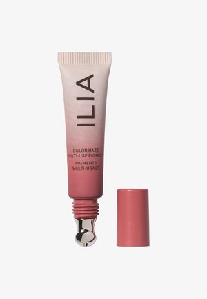 ILIA Color Haze Multi-Use Pigment in un tubo rosa a compressione con applicatore e cappuccio argentati. Texture liscia, design a colori sfumati.