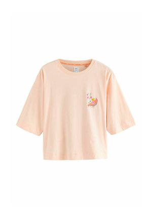 Leichtes Baumwoll-T-Shirt in Pfirsichfarben mit kurzen, weiten Ärmeln. Mit floralem Design auf der linken Brust bedruckt. Lässige, kastige Silhouette.