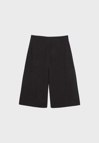 Shorts noirs larges aux genoux avec passants pour ceinture, disposés à plat sur un fond clair.