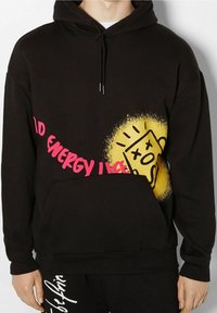 Sudadera negra con capucha, bolsillo tipo canguro en la parte frontal y un audaz diseño gráfico en amarillo y rosa con arte abstracto.