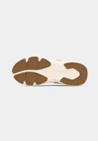 Semelle de sneaker avec une base en caoutchouc blanc et un motif de traction marron contrastant. Présente une finition texturée et un design distinct à segments multiples.