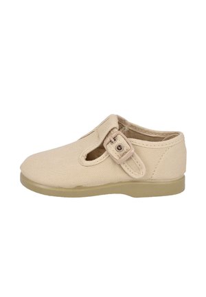Zapato beige para niño pequeño con parte superior de tela, correa lateral con hebilla, detalle recortado y suela de goma plana.