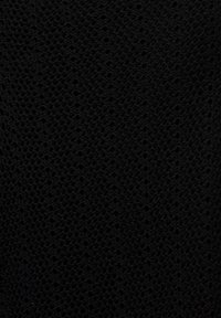 Tissu tricoté noir avec un motif en maille ouverte, présentant de petits trous espacés uniformément. La texture semble douce et flexible.