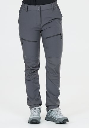 Graue Outdoor-Hose mit Reißverschlusstaschen am Oberschenkel, elastische Bundakzente, getragen mit grauen Wanderschuhen.