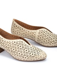 Chaussures en cuir perforé beige avec des motifs découpés floraux, forme de bout en amande et petit talon carré. L'intérieur présente une doublure lisse marron.