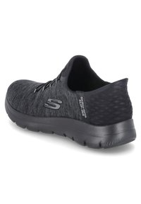 Schwarzer Sportschuh mit strukturiertem Obermaterial, schlankem Design, Schnürverschluss und abgerundeter Sohle; verfügt über ein dezentes Logo an der Seite.