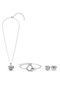 Ensemble de bijoux en argent comprenant un collier avec un pendentif en forme de cœur, un bracelet avec un motif en cœur et des boucles d'oreilles clous assorties en forme de cœur avec des pierres transparentes.