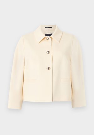 Εκρού κοντό σακάκι με μυτερό γιακά, τρία διακοσμητικά κουμπιά στο μπροστινό μέρος και μακριά μανίκια.