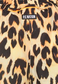 Leopardprint-Shorts aus glattem Stoff mit elastischem Bund und kleinem Reißverschlusstaschen mit kontrastierendem orangefarbenem Besatz. P.E Nation-Logo sichtbar.