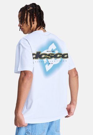 Biały bawełniany t-shirt z niebieskim gradientem i graficznym logo w kolorze czarnym i żółtym na plecach, krótkie rękawy, luźny krój.