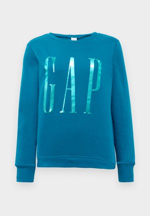 Turkusowa bluza z długimi rękawami, okrągłym dekoltem i błyszczącym srebrnym logo "GAP" z przodu. Miękki materiał o gładkiej teksturze.