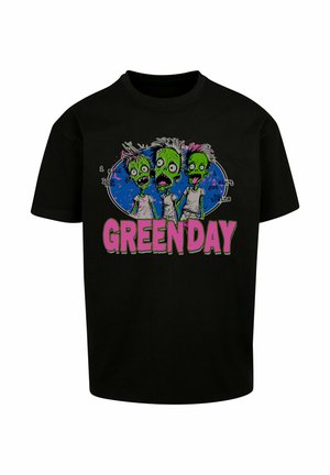 T-shirt in cotone nero con grafiche di zombie colorati, con pelle verde e capelli colorati; "GREEN DAY" in lettere rosa in grassetto sotto il design.