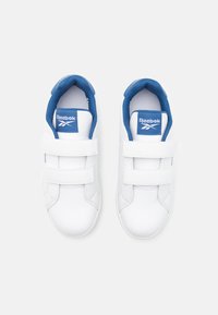 Hvite Reebok-sko med blå detaljer, som har to borrelåsremmer, avrundet tådesign og teksturert materiale på innersålen.