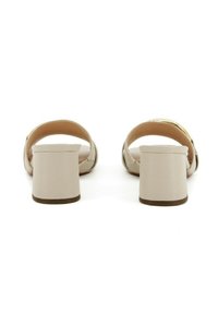 Sandali con tacco blocco beige, dalla finitura liscia, con retro aperto e cinturini larghi. Presentano un accento dorato sottile sopra il tallone.