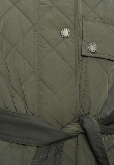 Oliven grøn quiltet jakke med bælte i taljen, trykknapper og en lomme med en sølvlogo-detalje. Glat tekstur, praktisk design.