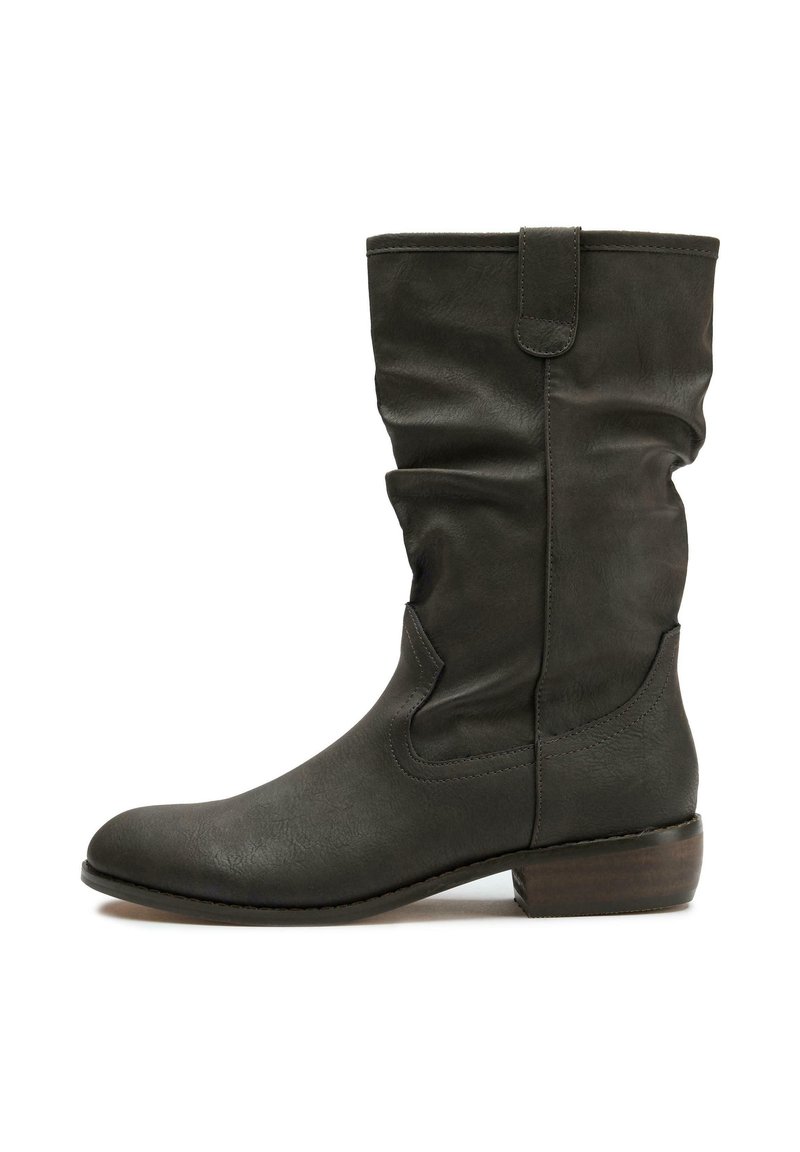 Dark green leather knee-high boot with a slouchy design, rounded toe, low stacked heel, and tab detail at the top. Smooth texture.