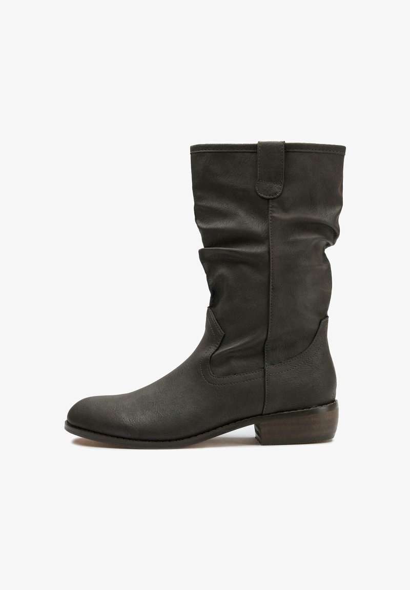 Dark green leather knee-high boot with a slouchy design, rounded toe, low stacked heel, and tab detail at the top. Smooth texture.