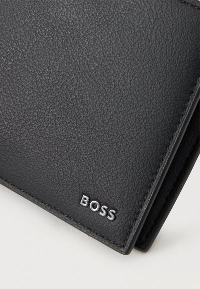 Portefeuille en cuir noir texturé avec logo métallique argenté "BOSS" en bas à droite sur fond blanc.