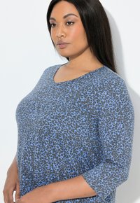 Grijze top met blauw luipaardprintpatroon, ronde halslijn en driekwartmouwen. Gemaakt van een zachte, gestructureerde stof.