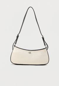 Τσαντάκι ώμου σε κρεμ χρώμα με μαύρες λεπτομέρειες και ασημένιο λογότυπο, με καμπύλο σχέδιο και λείο φινίρισμα υλικού.
