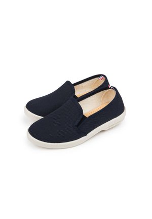 Baskets slip-on en toile marine avec inserts élastiques sur les côtés, semelle en caoutchouc blanc et design minimaliste. L'intérieur présente une doublure beige.