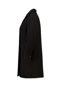 Manteau en laine noir, longueur genoux, avec manches longues, col cranté, poches latérales et détail de bouton unique sur les poignets, vu de côté.