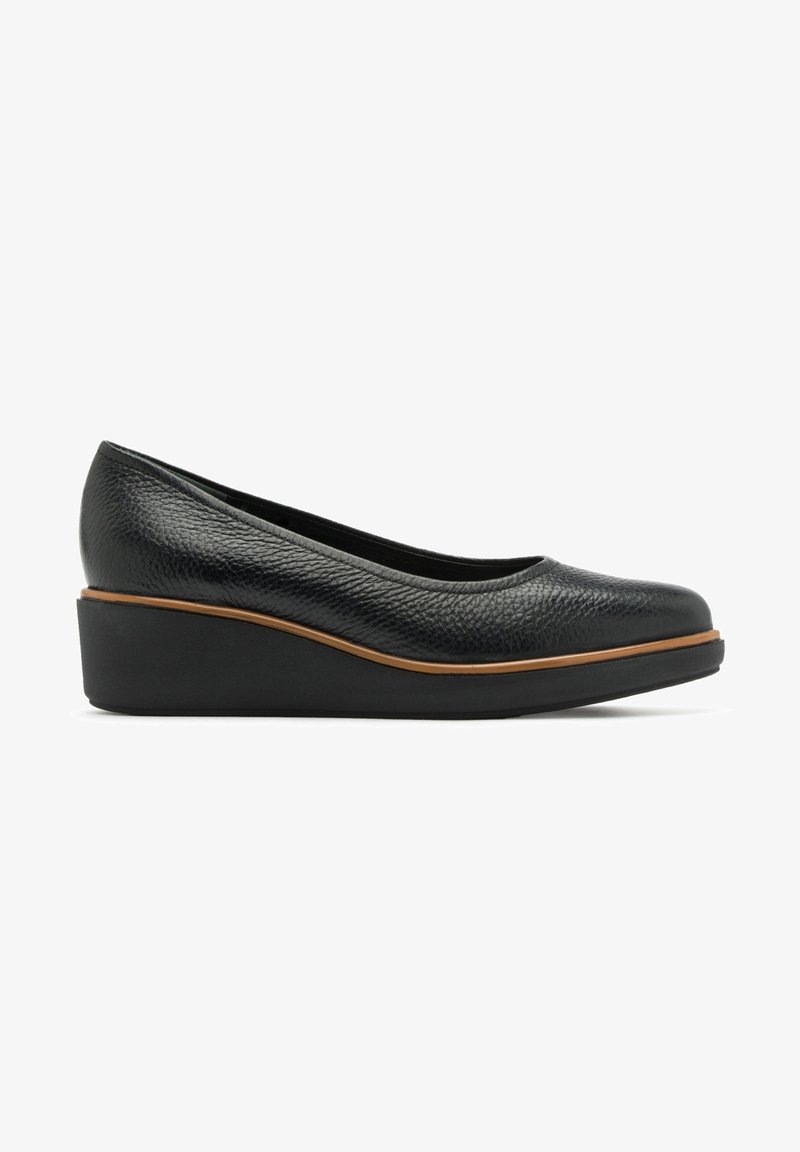 Chaussure compensée en cuir texturé noir avec un petit talon et une bordure marron au-dessus de la semelle, vue de profil sur fond blanc.