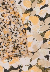 Miękka tkanina w jasnoróżowym tle z abstrakcyjnym wzorem w ziemistych odcieniach pomarańczowego, brązowego i czarnego. Szczegóły strzępienia brzegów.