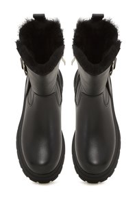 Botas de cuero negro con un acabado suave, que cuentan con un suave forro de piel negra en la parte superior y una cremallera lateral para un acceso fácil.