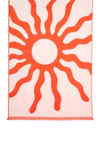 Bawełniany ręcznik plażowy z dużym pomarańczowym słońcem z falistymi promieniami na jasnoróżowym tle. Zawiera frędzle na brzegach.