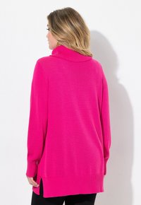 Fuchsiastrickad tröja med en krage, långa ärmar, ribbade manschetter och nederkant, med sidoveck för ökad rörelsefrihet och en avslappnad passform.