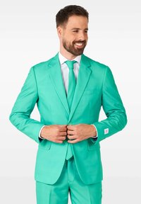 Completo teal brillante con colletto a trombetta, chiusura a un bottone e due tasche frontali. Abbinato a una camicia bianca e una cravatta coordinata.