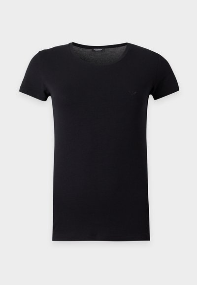 Μαύρο εφαρμοστό T-shirt με κοντά μανίκια, στρογγυλή λαιμόκοψη και διακριτικό λογότυπο στο αριστερό μέρος του στήθους σε ανοιχτό φόντο.