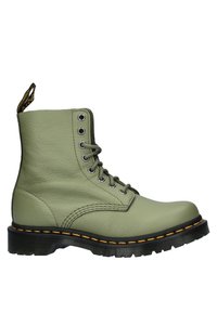 Botín de cuero verde hasta el tobillo con punta redonda, suela texturizada negra, costuras amarillas, ojales de metal y una lengüeta en el talón.