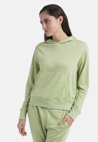 Sudadera verde claro con una tela texturizada y suave, que cuenta con un bolsillo tipo canguro, puños acanalados y capucha con cordones.