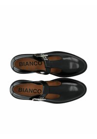 Black leather Mary Jane-style shoes with a strap, silver buckle detail, and open cutouts above the toes. Leather insole; brand "BIANCO" visible.